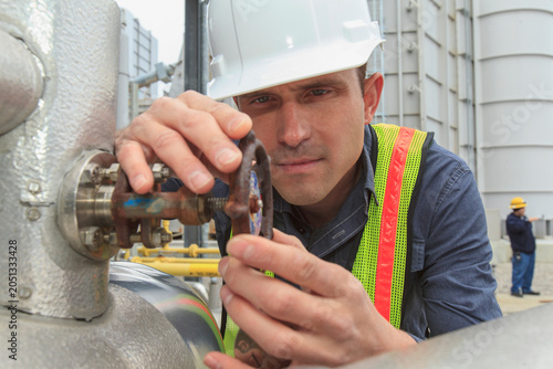 Industrial engineer checking valve corrosion at a power plant