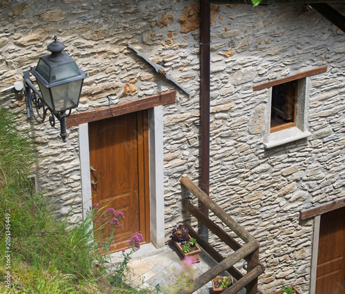 The stone facade of an ancient and beautiful house, stone roofs in the village of Isola Santa on the shore of the homonymous lake, magic in the heart of the Apuan Alps, in the province of Lucca