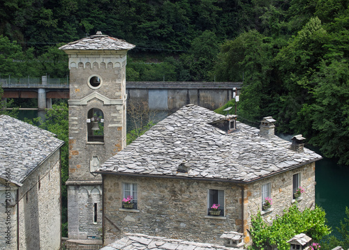 The stone facade of an ancient and beautiful house, stone roofs in the village of Isola Santa on the shore of the homonymous lake, magic in the heart of the Apuan Alps, in the province of Lucca
