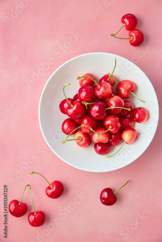 Fresh Red Cherries in White Bowl on Pink Background, Top View