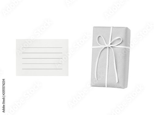 Overhead view of a pale gray gift box tied with a white ribbon and a white lined card