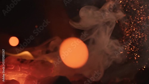 Glowing orange smoke, vibrant particles, dark background, abstract, fiery atmosphere, smoke effects
