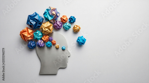 Head with colorful origami geometric shapes representing creativity, mental health, psychology, and innovation.