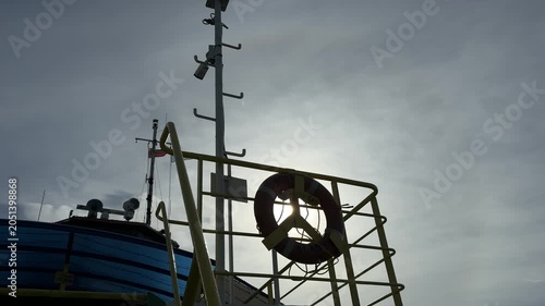 Backlit lifebuoy and mast on ferry deck