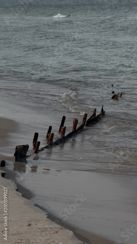 Waves washing over old wooden groynes on Baltic shore