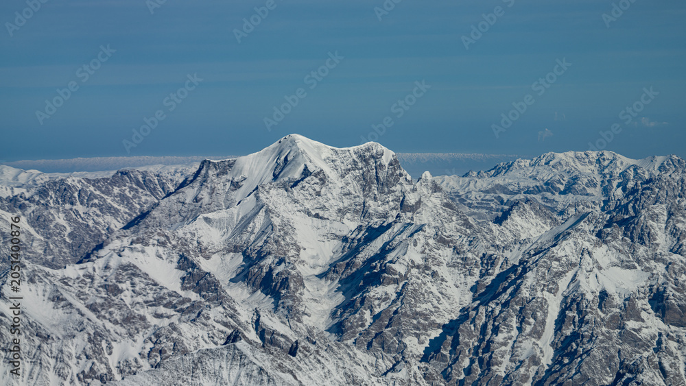 Obraz premium Rugged snow covered mountain peaks viewed from above