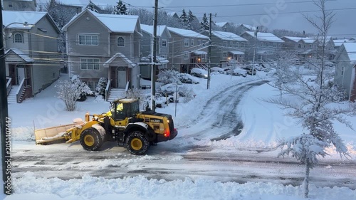 Snow blankets Halifax in winter, as powerful snowplows carve paths through the deep drifts, revealing serene suburban streets amidst the frosty landscape
