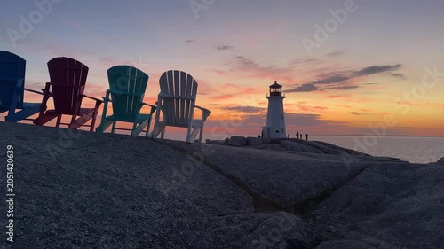 Sunset at Peggy's Cove lighthouse with chairs and ocean view in Nova Scotia near Halifax