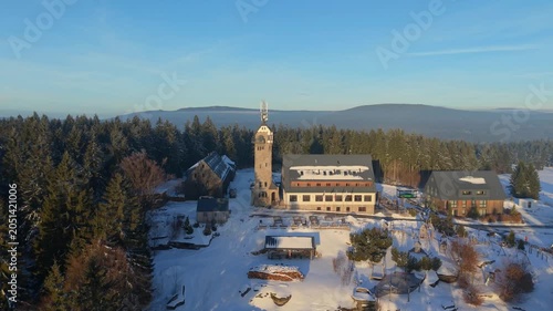 View the Kralovka lookout tower in the Jizera Mountains during winter. See the tower and surrounding area covered in snow. Enjoy the view from the elevated spot in winter landscape.