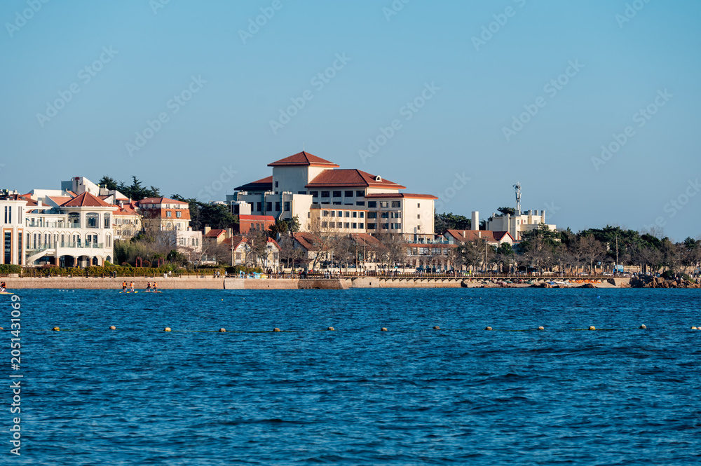 Fototapeta premium European style seaside buildings with blue ocean under clear sky in Qingdao, China