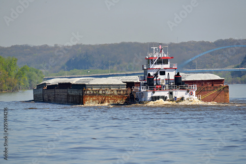 Rear view of a Tug boat pushing a large set of barges North up the Mississippi River