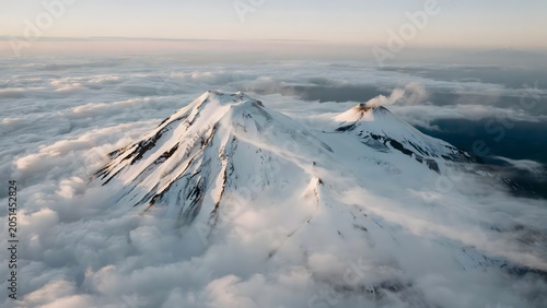 Snow-Covered Mountain Peaks Rising Above Cloud Layer at Sunrise