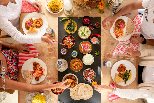 Quadro em tela Gathering for a Vibrant Indian Feast With Family and Friends at a Sunny Table