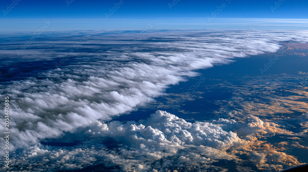 Fototapeta premium Aerial view of stratiform cloud layer at altitude captures natural atmospheric gradient transition where moisture density creates banded tonal progression across wide horizon panorama, meteorologica