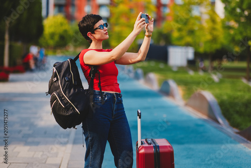 Solo female traveler documenting city vacation with smartphone