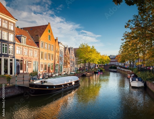idyllic scenic view of traditional historic buildings and boats on a canal in a quaint european town