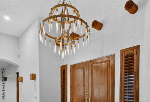 Obraz na plátne Interior entry with circular chandelier and wooden doors