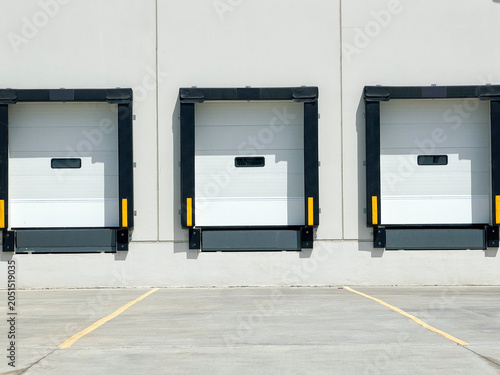 
Loading dock doors on warehouse exterior wall with empty concrete yard