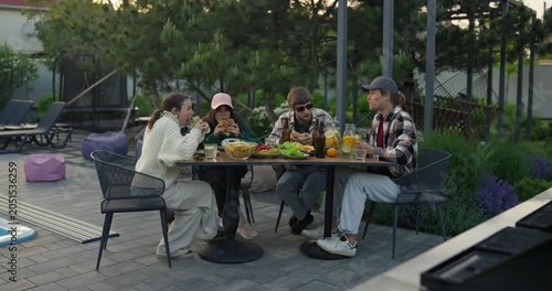 Young adults sharing an evening meal at a garden patio table