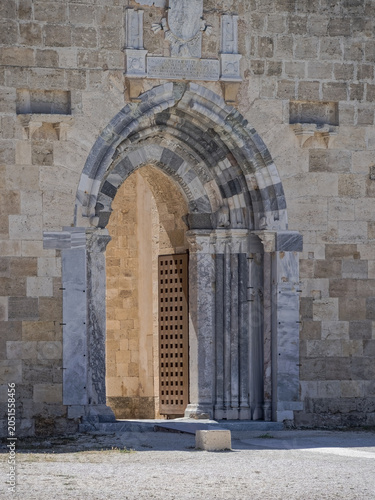 Beautifully preserved gothic marble arch and royal shield at the entrance of Castello Maniace, Siracusa, Italy. Architectural heritage of an iconic Mediterranean seaside fortress.