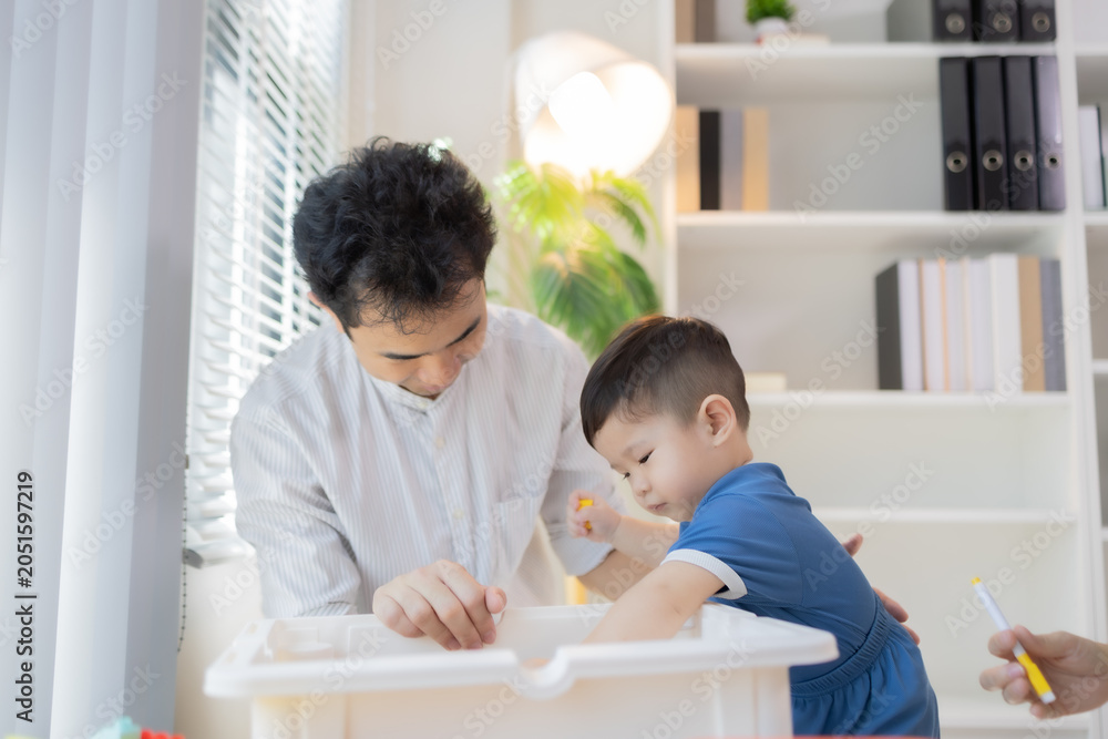 Obraz premium Young family shares joyful moments on floor. Parents smile warmly while playing with child. Child laughs happily in parents' arms. Bright colors and toys fill cozy living room 