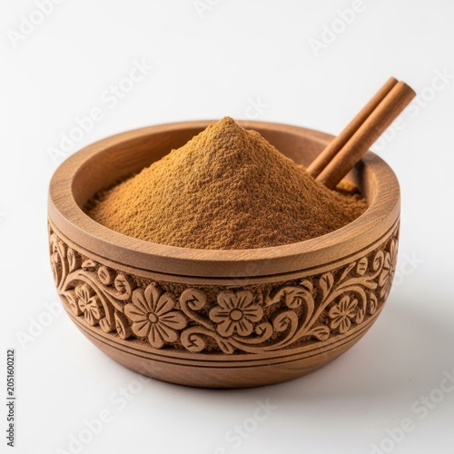 Cinnamon powder and sticks in a carved wooden bowl