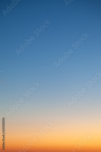Clear and empty blue and yellow orange gradient sky for background, vertical image