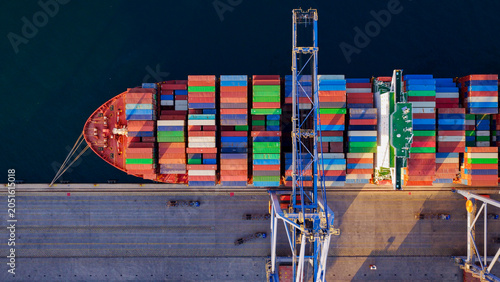 Fotografie Large container ship docked at a commercial port, featuring a gantry crane loadi