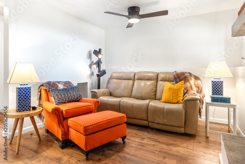 Фотография Cozy living room with beige sofa and orange armchair