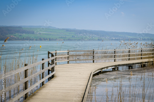 Curving wooden boardwalk over a calm lake
