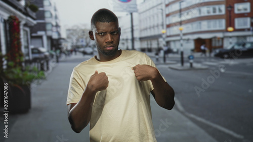 Bild auf Leinwand Man points finger to chest on street with tense, questioning expression and clenched fist near chest; defensiveness