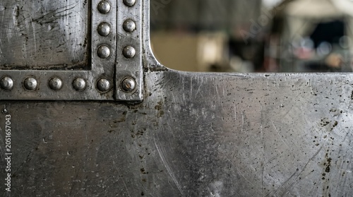 Scratched industrial metal plate with rivets background texture