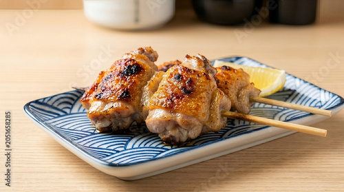 香ばしく焼き上げた鶏もも串の焼き鳥、レモン添え