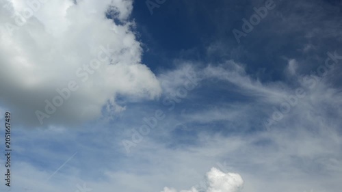 Puffy clouds moving across blue sky timelapse