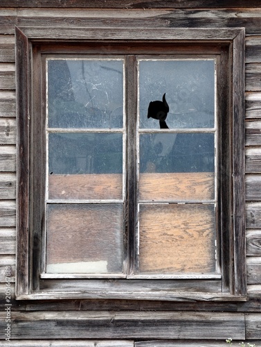 Obraz na płótnie Weathered wooden window with cracked glass and boarded lower panes