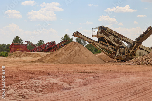 Industrial crushing machine processing aggregates in quarry site.
