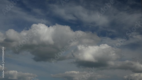 Puffy clouds moving across blue sky timelapse