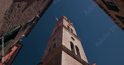 Historic stone clock tower viewed from a narrow street in the old town of Sibenik Croatia.