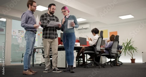 Team members discuss project details while working in a modern office space during the afternoon hours with a focus on collaboration and planning