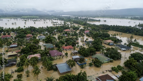 Severe flooding covers a rural tropical community with murky water, showing the devastating impact of extreme weather and climate change.