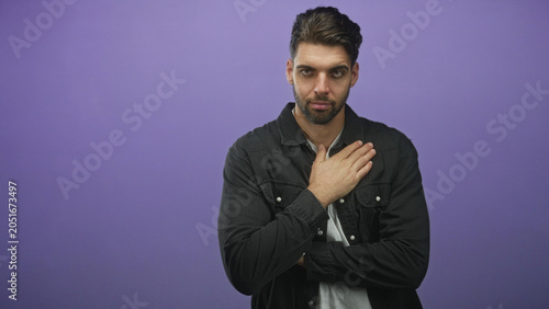 Принти на полотні Hispanic man with beard, hand on chest and crossed arms in other frames, looking at camera against purple studio backdrop; sincerity pledge