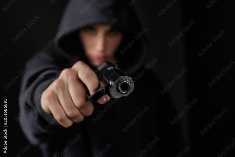 Foto Armed Robber Pointing Gun in Dark Setting