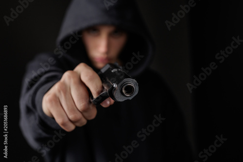 Schilderij op canvas Armed Robber Pointing Gun in Dark Setting