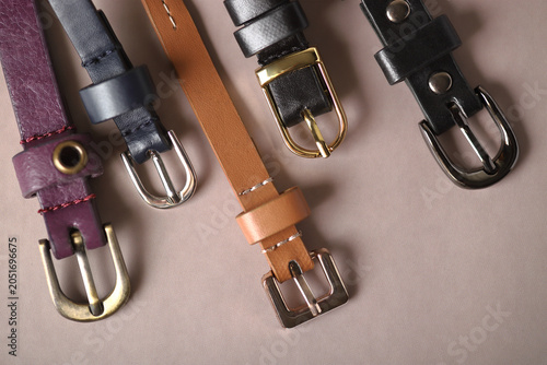 Several leather belts with diverse decorative buckles.
