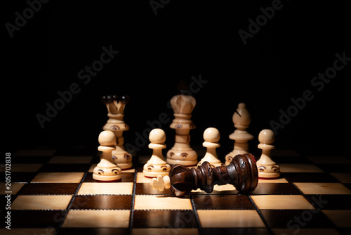Canvas Print Chess king lying defeated among standing pieces on a board, symbolizing strategy, leadership, victory, failure, decision‑making, competition and business conflict