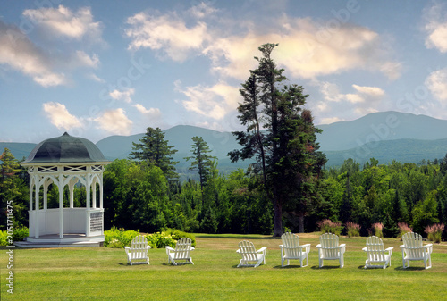 Springtime in White Mountains of New Hampshire. Relax in one of the comfortable Adirondack chairs and enjoy this scenic view of lush green forest and distant mountains.