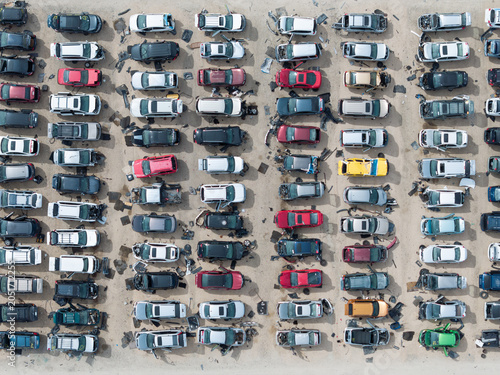 Top-down shot captures numerous scrapped cars in a scrap yard