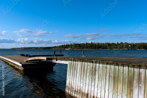 scenic lakeside view with wooden pier and blue sky