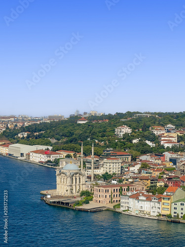 Istanbul, Turkey - July 21, 2024: View from 0-1 freeway, driving over the Bosphorus bridge that leads to the Asian part of the city: Buyuk Mecidiye Mosque on the shoreline together with dense building