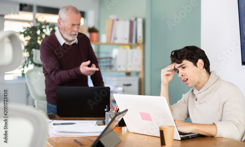 Foto Senior male manager is dissatisfied with the work of an employee - yells and rep